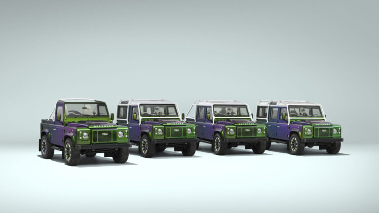 Five Land Rover Defender SUVs in purple and green lined up on a pale blue backdrop.